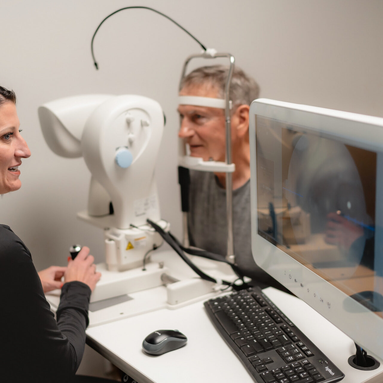 DSC04021 Dr. Becky runs an eye exam on older man